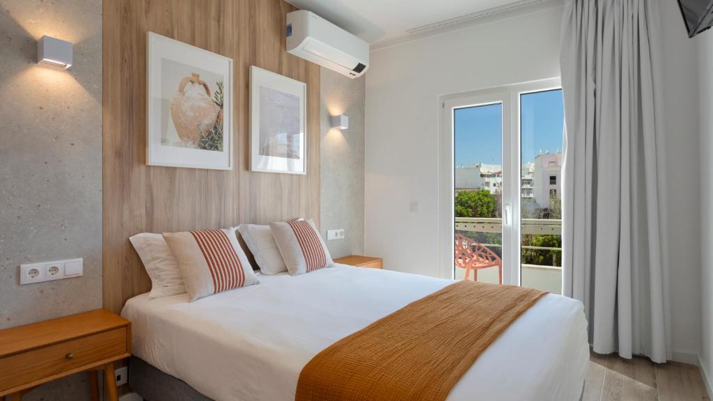 法鲁Hotel Made inn Faro的酒店客房设有一张床和一个大窗户