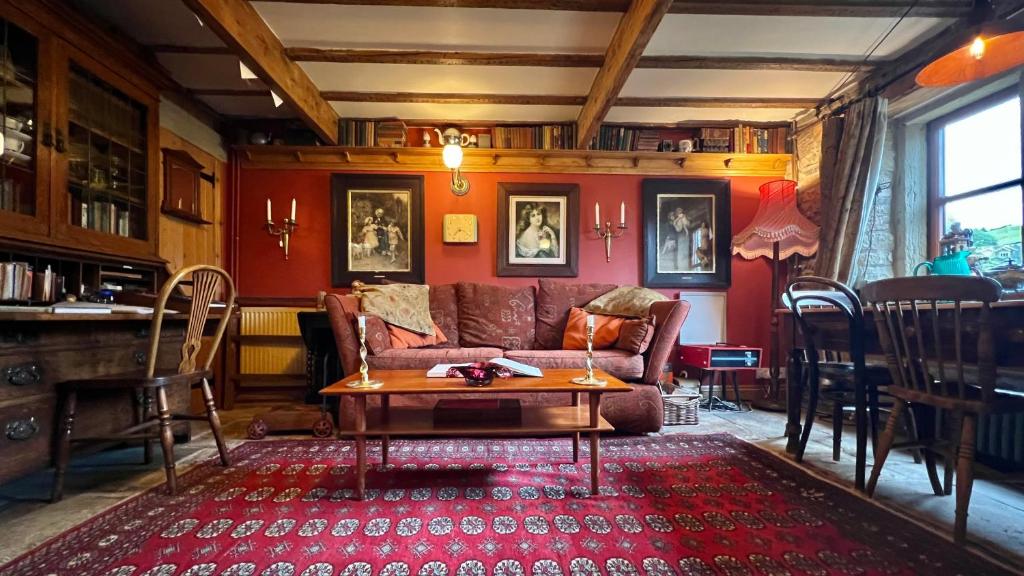 霍姆弗斯The Writers Cottage - Intriguing & Romantic的客厅配有沙发和桌子