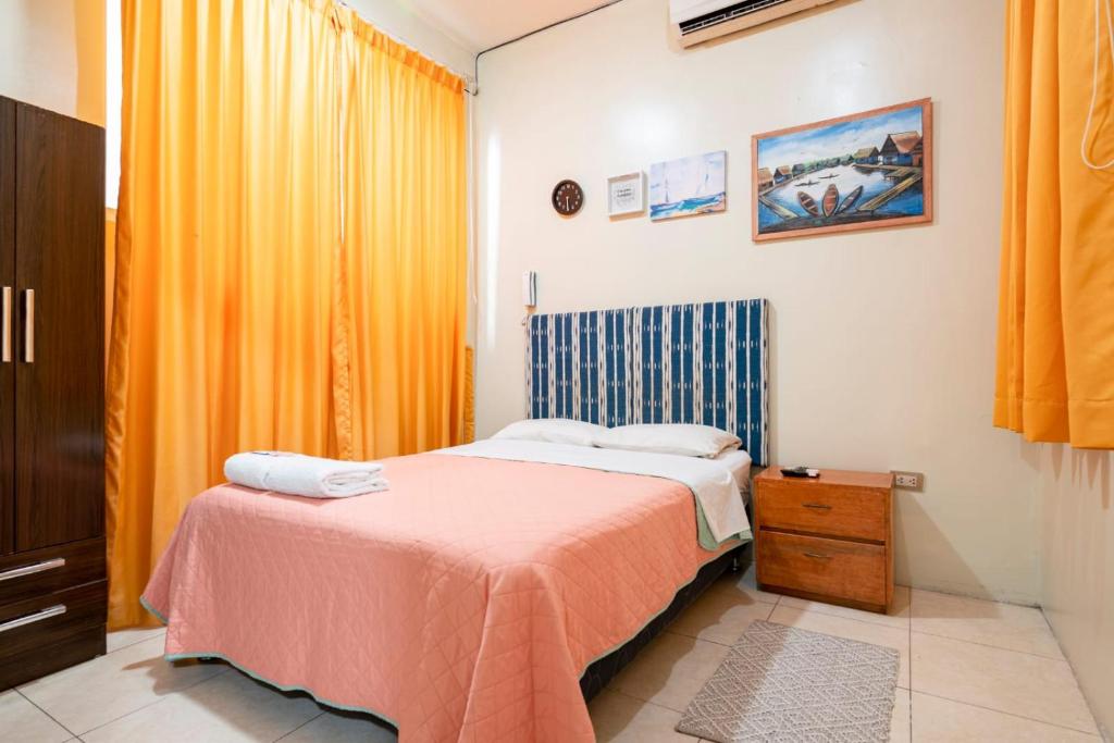 伊基托斯203 RV Apartments Iquitos-Apartamento con dos habitaciones的一间卧室配有一张带粉色毯子的床
