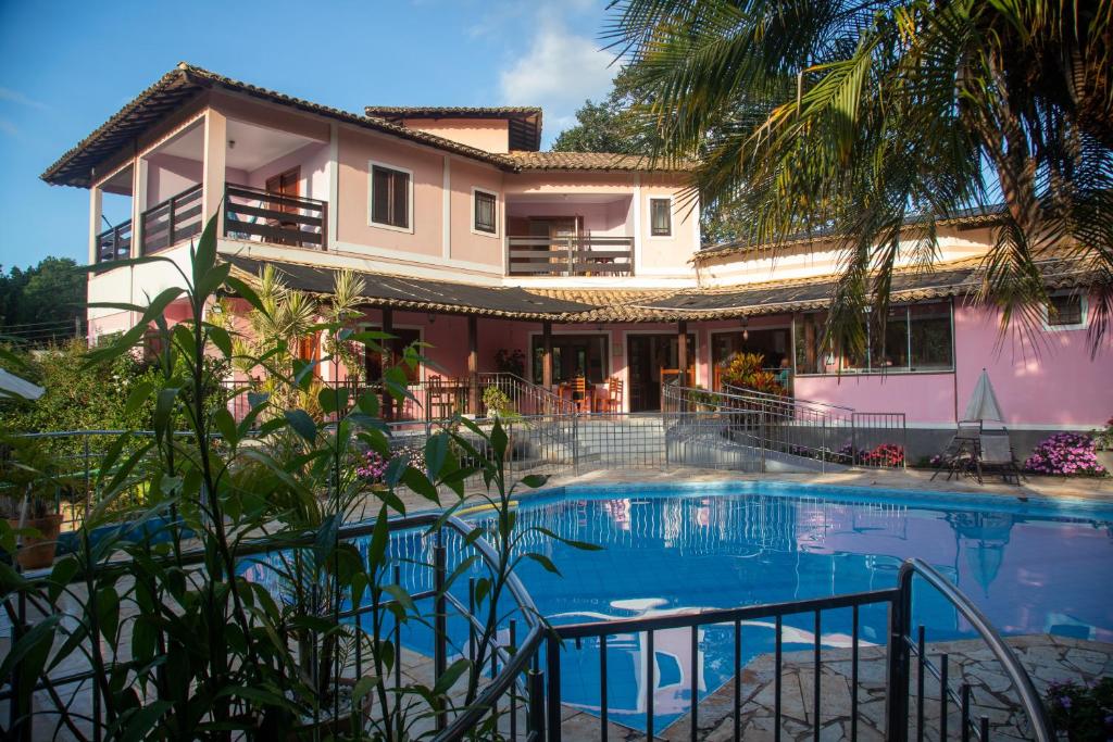 戈亚斯州上帕莱索Pousada Casa Rosa的房屋前有游泳池的房子