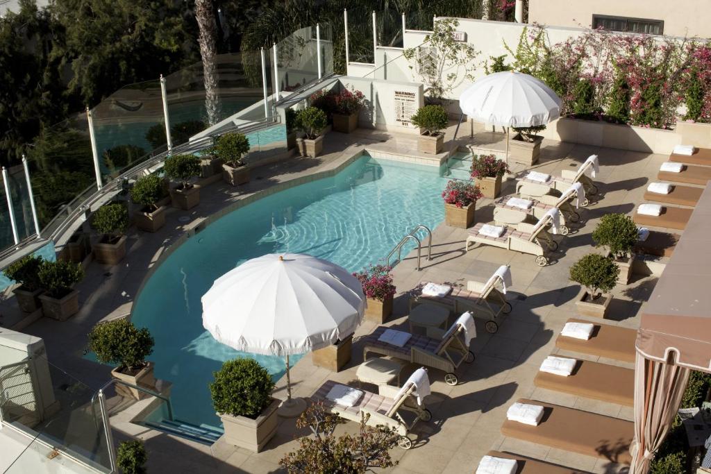 洛杉矶日落塔酒店的享有带椅子和遮阳伞的游泳池的上方景致
