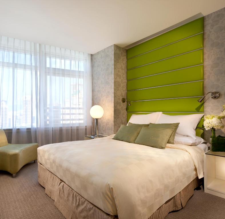 香港香港丽悦酒店的一间卧室配有一张大床和绿色床头板