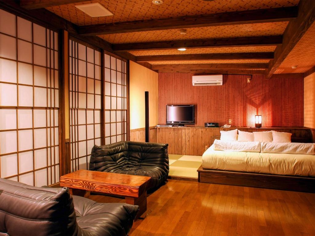 MiyajiTsuruya / Vacation STAY 59065的客房设有床、沙发和电视。