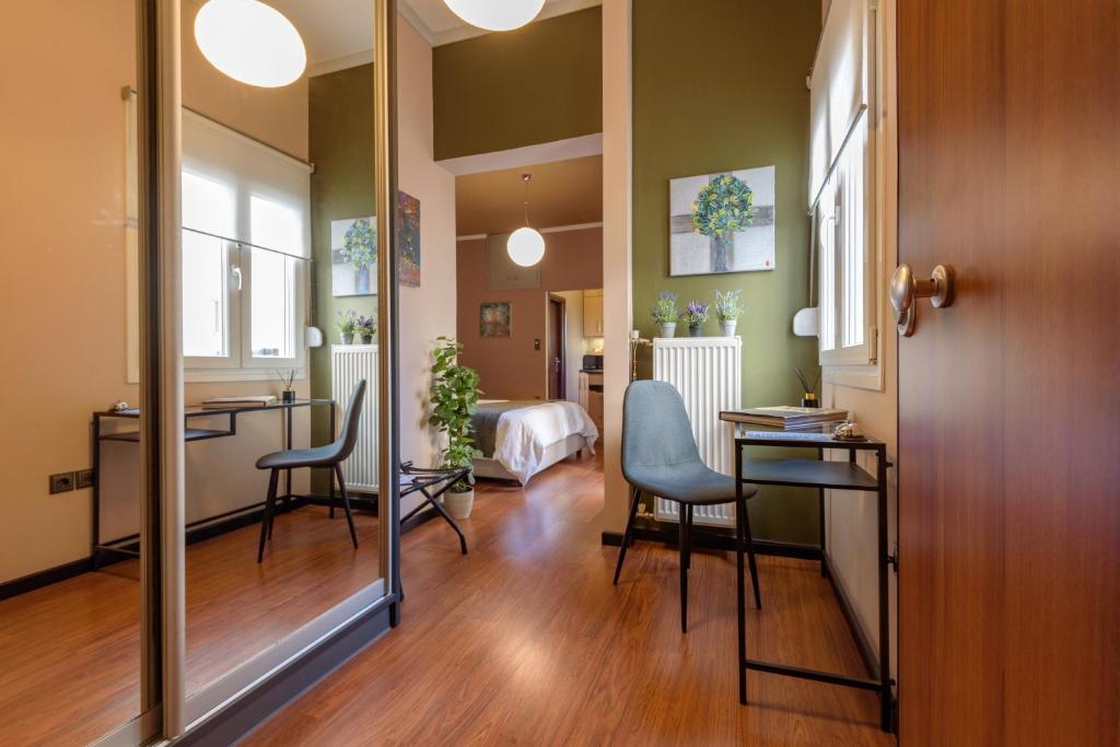 雅典阿莫尼克公寓的一间设有镜子、两把椅子和一张床的房间