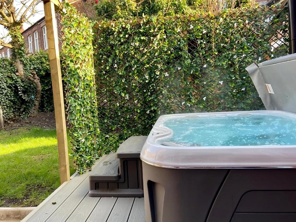 曼彻斯特The Safari House - Your Ultimate Relaxation Destination的露天平台上的热水浴池,有垃圾桶