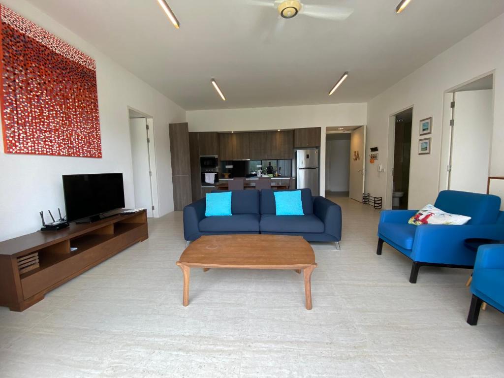 峇都丁宜By The Sea - UBTS SMART ENTERPRISE的客厅配有蓝色的沙发和桌子