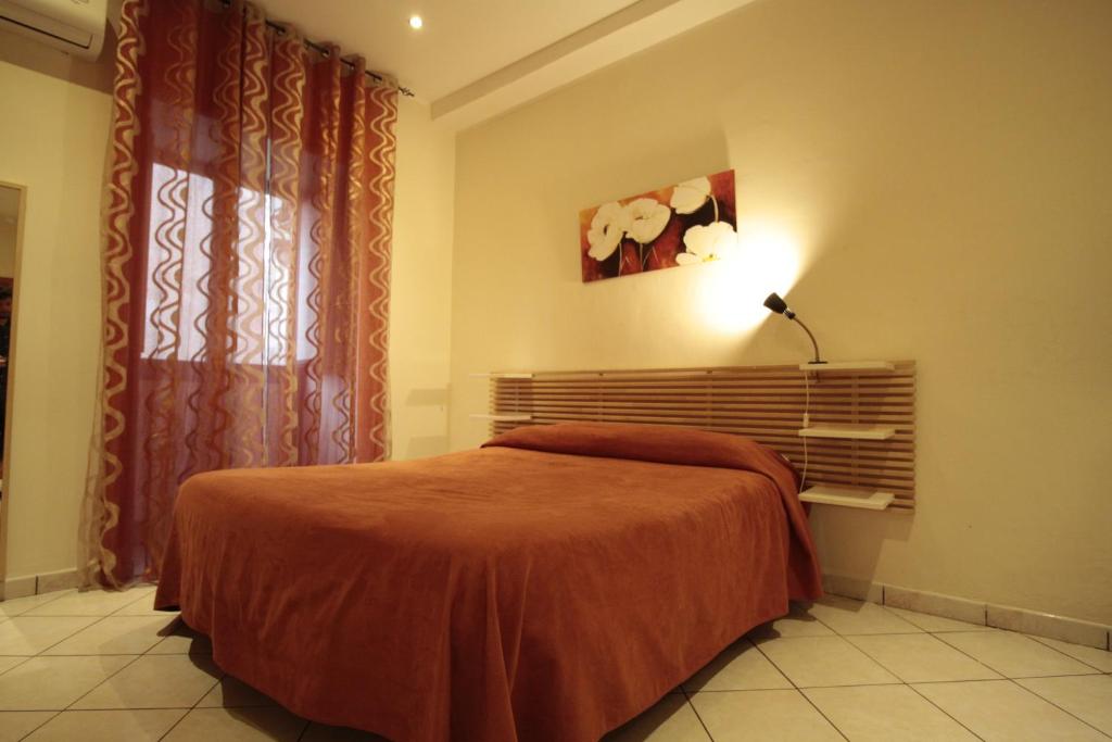卡塔尼亚维斯特公寓酒店的一间卧室配有床、灯和窗户