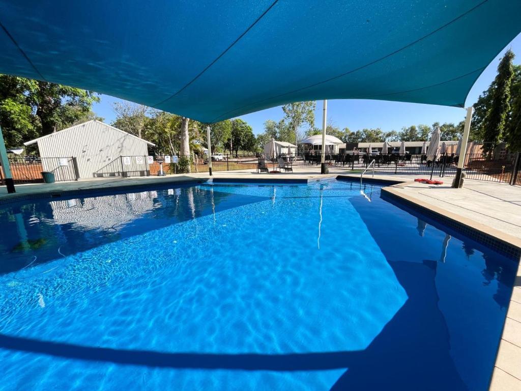 库努纳拉Lily Lagoon Resort的游泳池上方设有蓝色遮阳伞