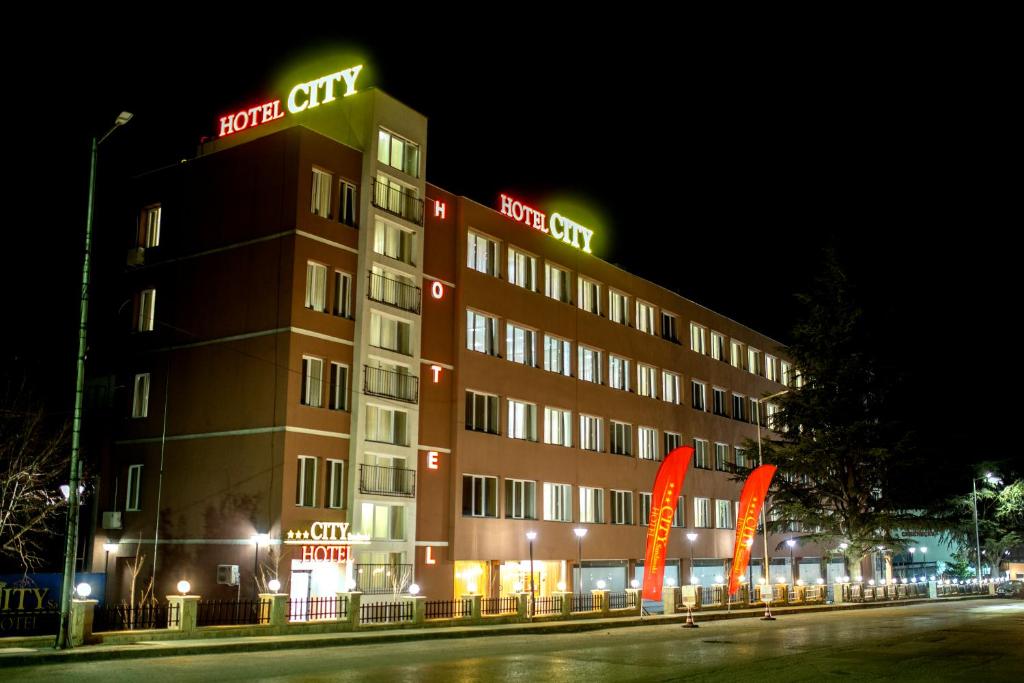 桑丹斯基Hotel CITY Sandanski的夜间标有标志的酒店大楼