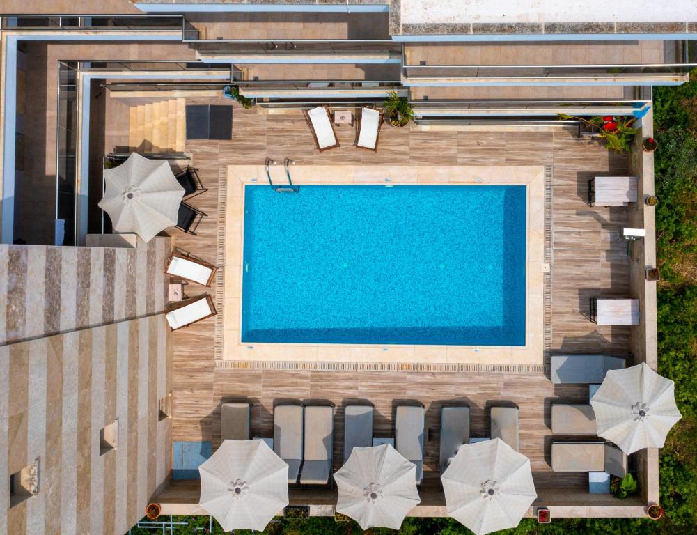 卡利塞亚-豪客迪克斯Vellum Luxury Living的享有带椅子和遮阳伞的游泳池的上方景色