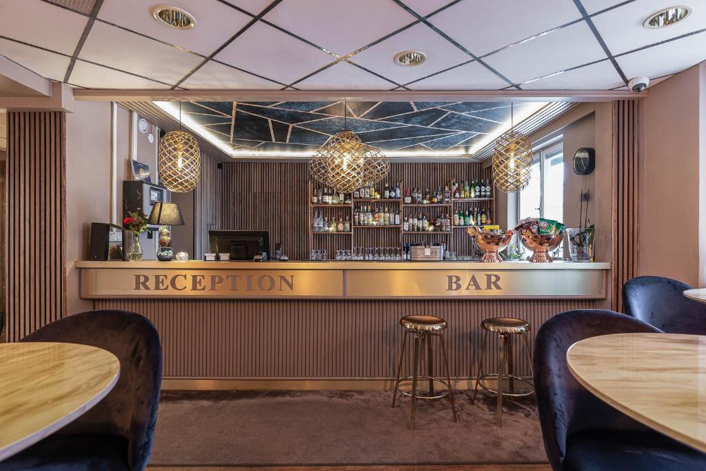 韦斯特罗斯阿卡德酒店的餐厅内的酒吧,设有桌子和凳子