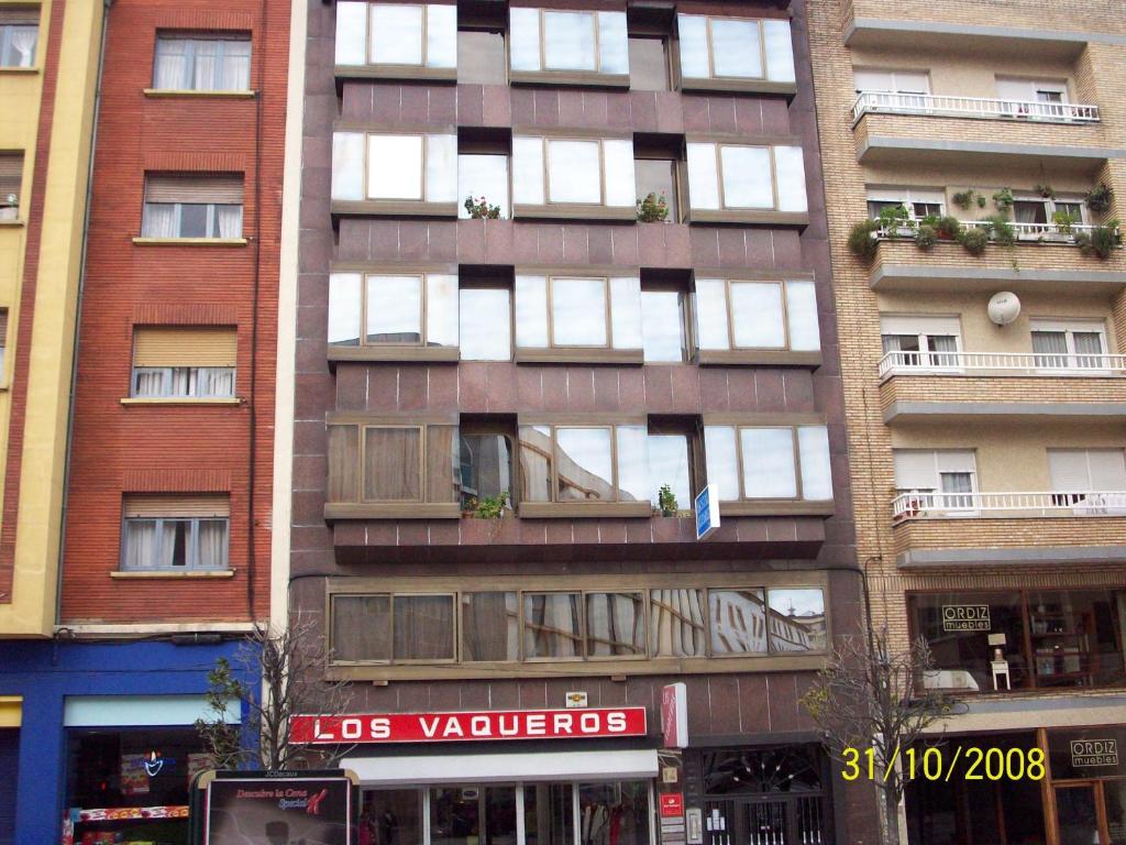 奥维多阿尔瓦雷斯旅舍的城市街道上一座高大的公寓楼,设有窗户
