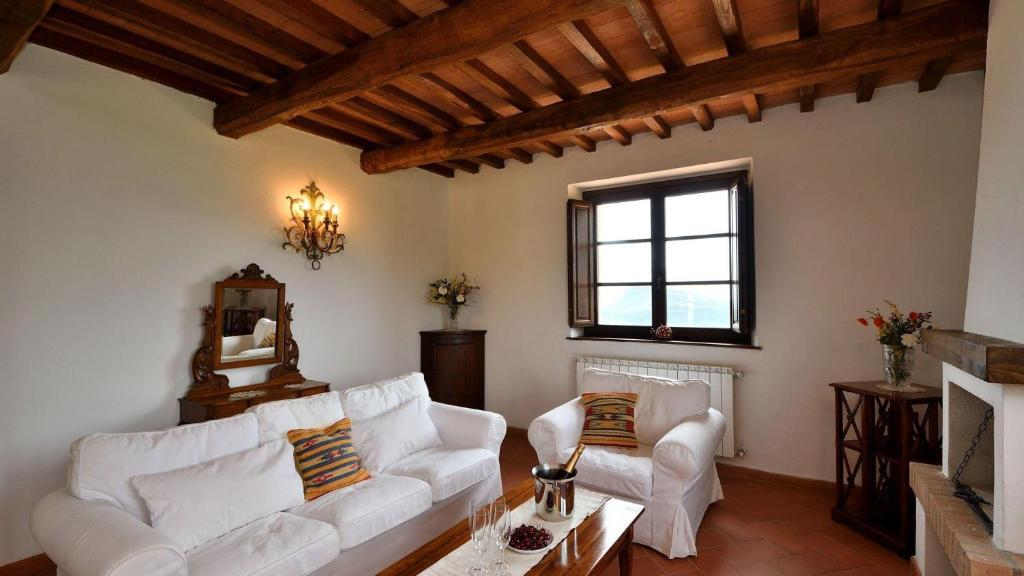 RoccalbegnaMelograno的客厅配有白色沙发和壁炉
