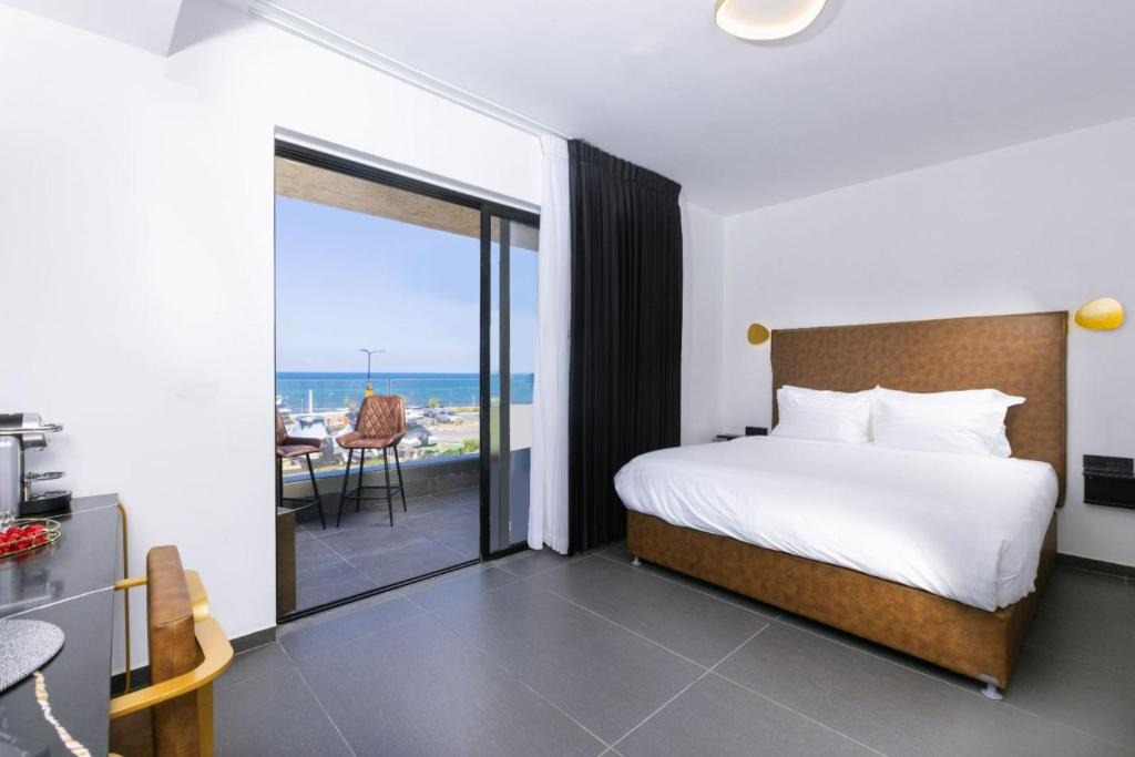 纳哈里亚מלון בוטיק H34的一间卧室配有一张床,享有海景