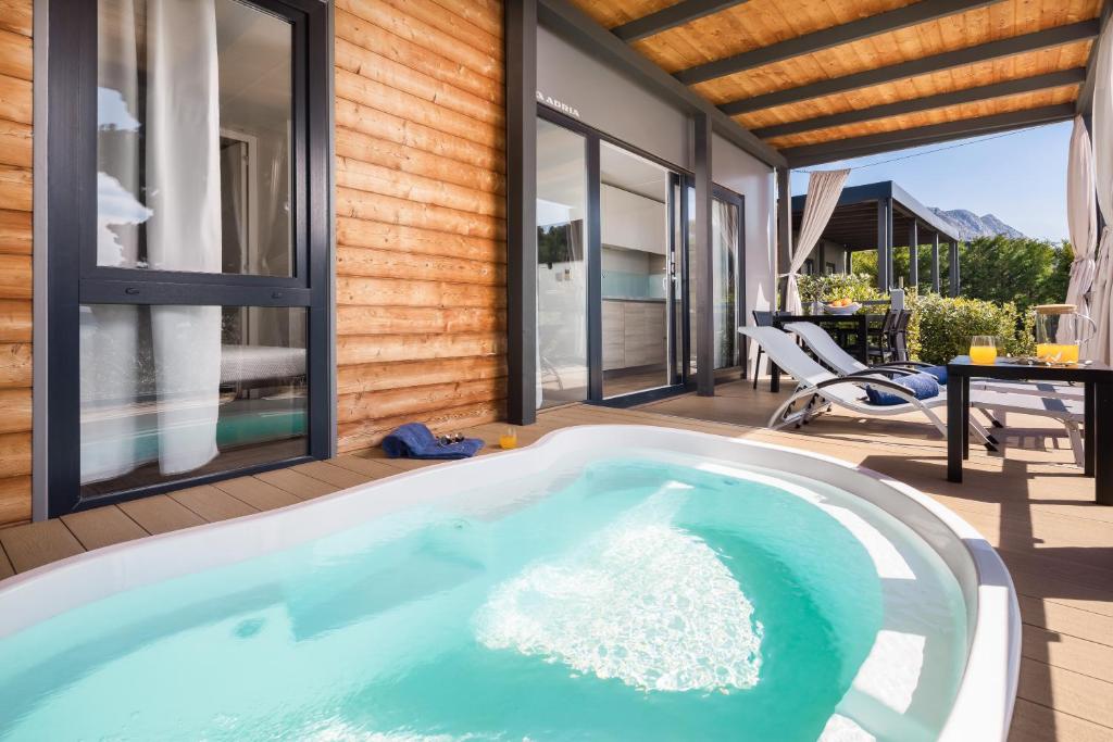伯德古拉Medora Orbis Mobile Homes & Glamping的一座带庭院的房屋内的热水浴池