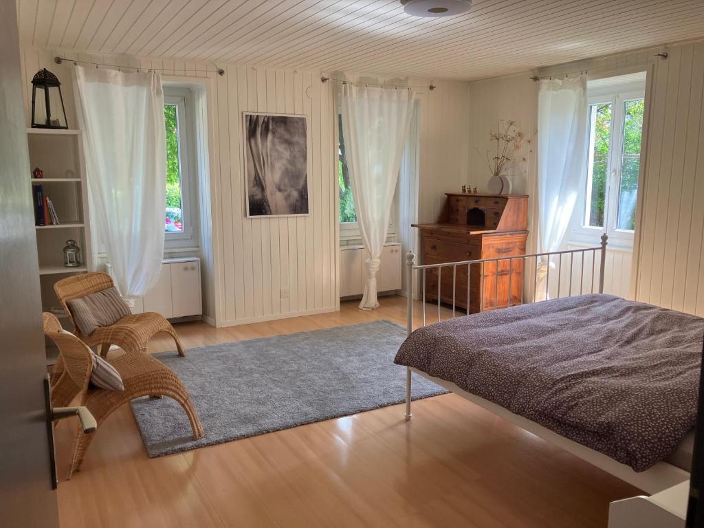 谢尔La Lanterne的一间卧室配有一张床、一把椅子和窗户。