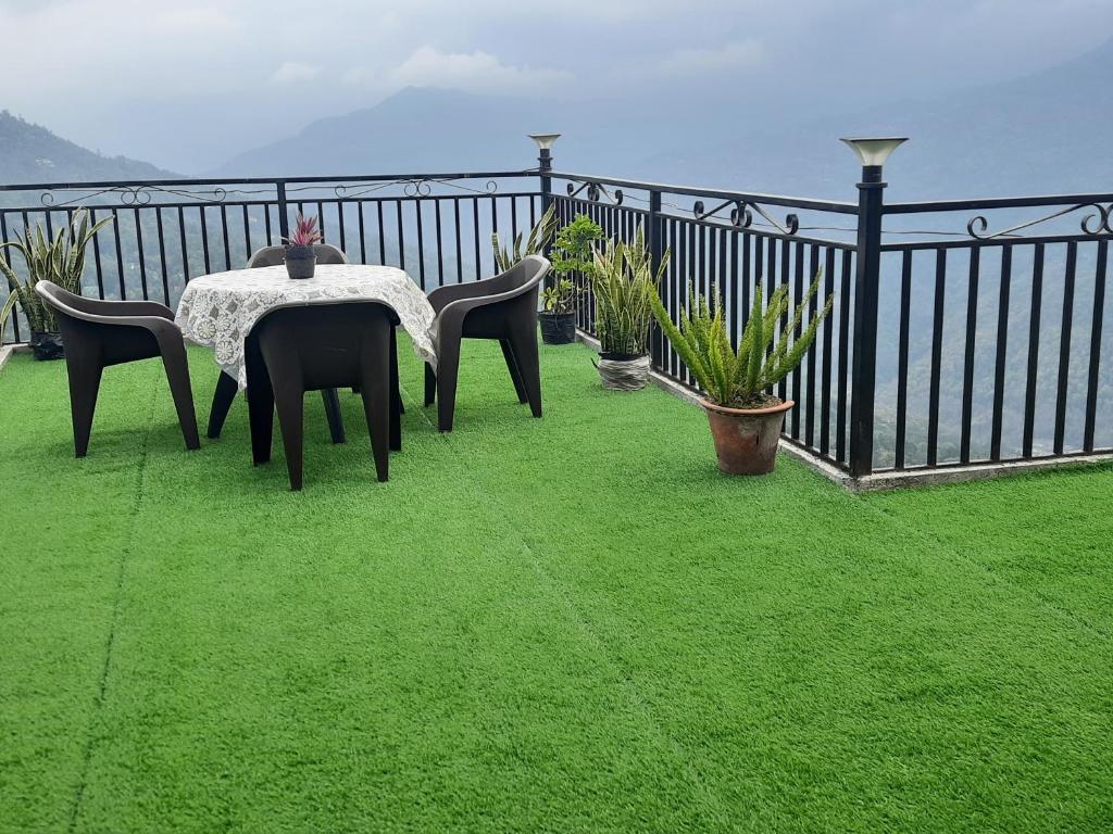 噶伦堡The Sangam Homestay的绿草阳台的桌椅