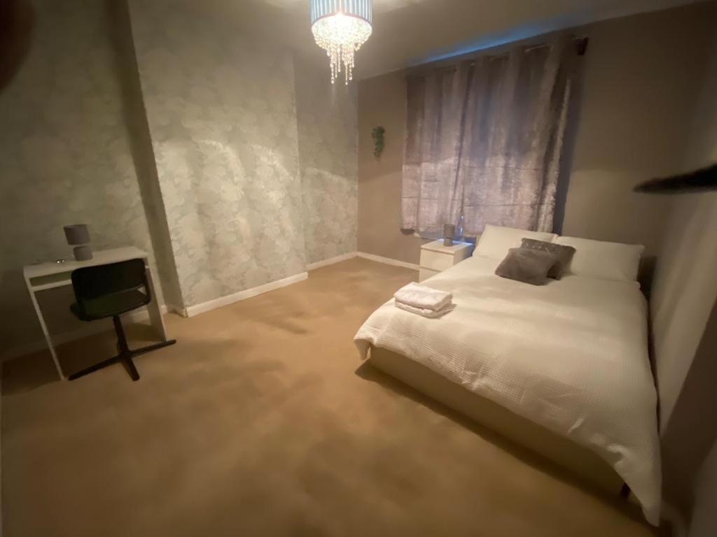 格拉斯哥Glasgow excellent lodging home的卧室配有白色的床和电视。