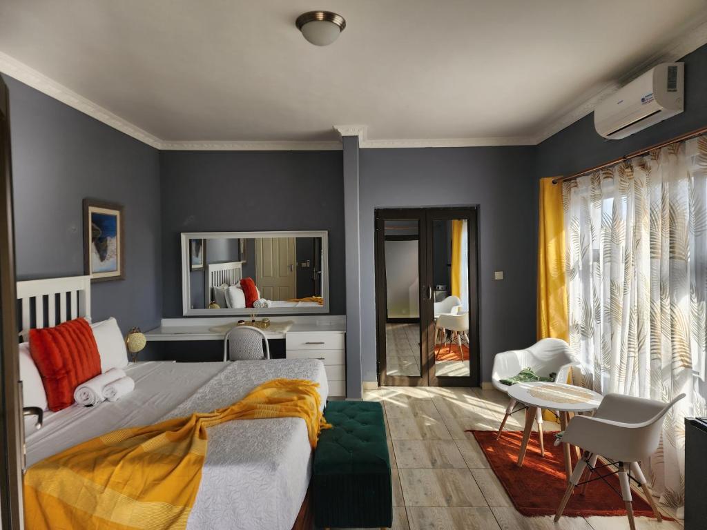 帕拉佩Minnestay Guest House的一间拥有蓝色墙壁的卧室,配有一张床和一张桌子