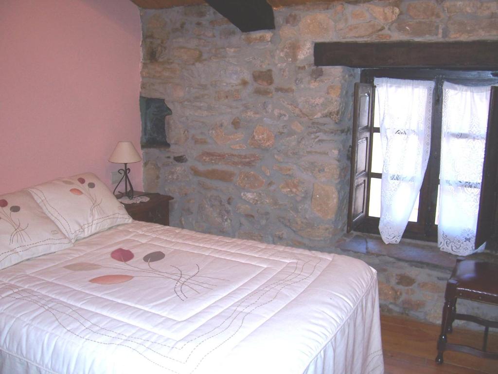 拉斯梅德拉斯Las Medulas Los Telares的一间卧室设有一张床和石墙