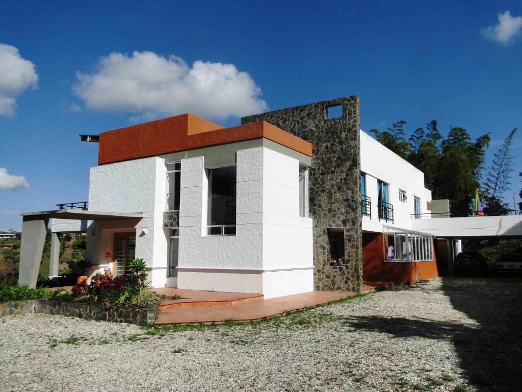 瓜塔佩Hotel Familiar El Remanso Del Agua的白色和橙色的房子,有院子