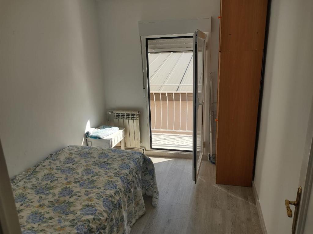 波苏埃洛-德阿拉尔孔Habitación individual en Pozuelo de Alarcón的一间卧室设有一张床,并有通往阳台的门