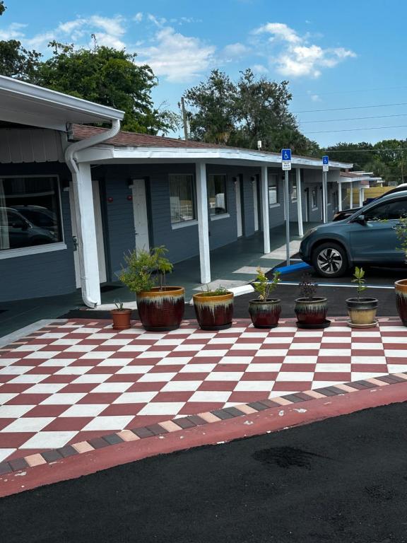 代托纳海滩代托纳比奇红地毯酒店的一座房子,设有种植了盆栽植物的停车场