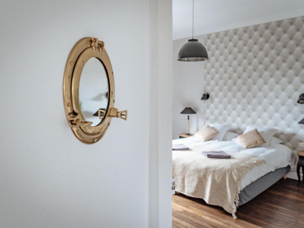 迪南La Villa Côté Cour的卧室配有一张床,墙上设有镜子