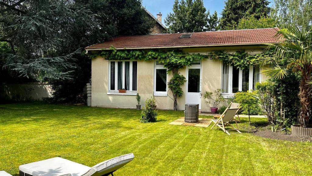 GagnyL Annexe - Parenthèse Champêtre PARIS DISNEYLAND的白色的小房子,带椅子的院子