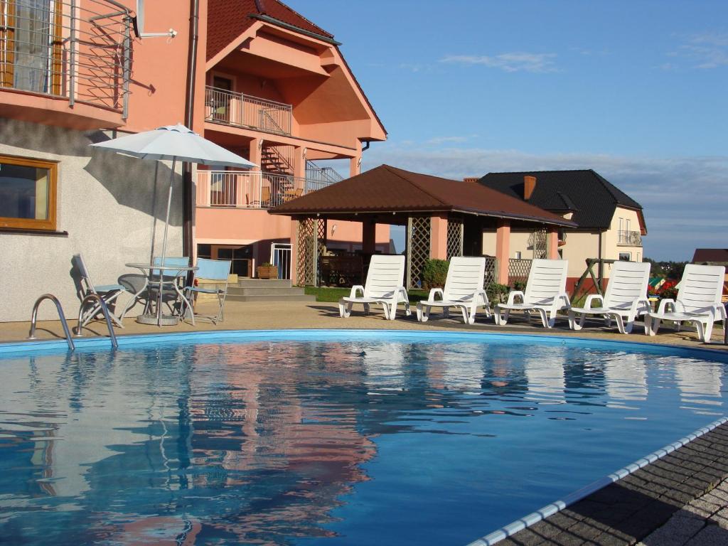 雅罗斯瓦维茨格利夫宾馆的一个带躺椅和遮阳伞的游泳池