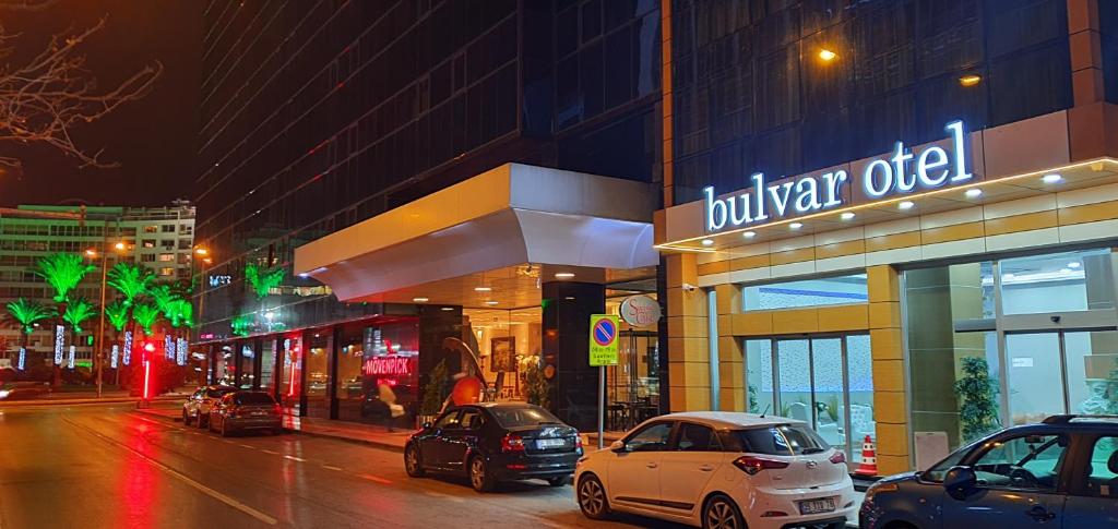 伊兹密尔Bulvar Hotel的一条城市街道,汽车停在大楼前