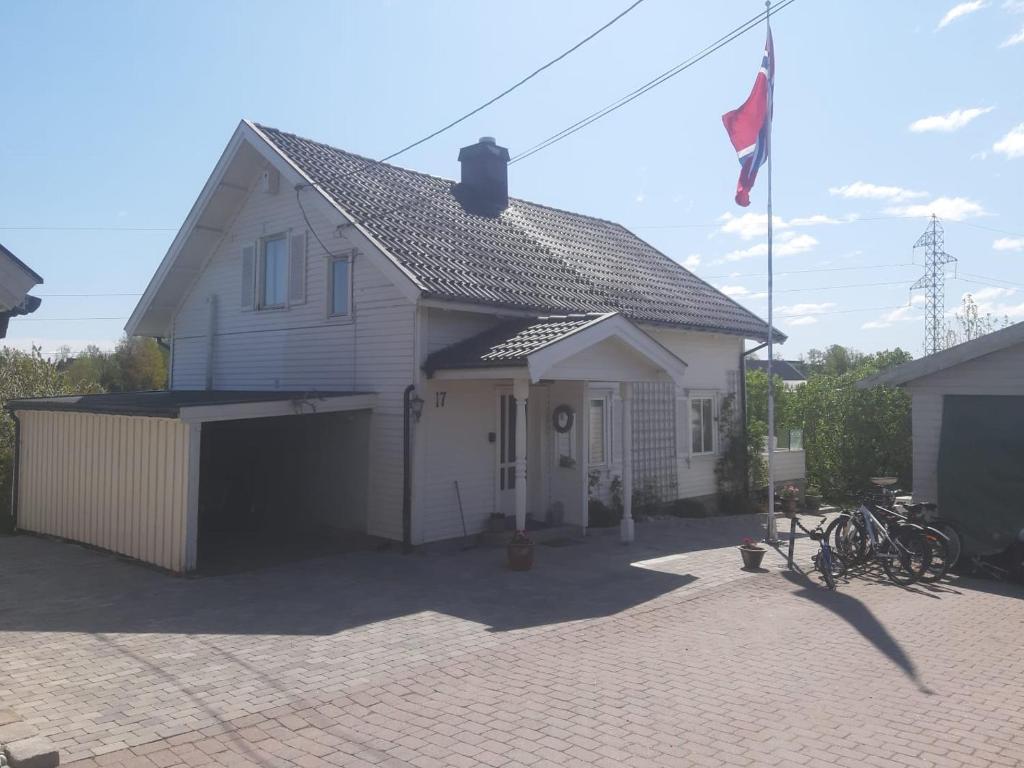 NøtterøyGamle huset på landet的前面有旗帜的白色房子