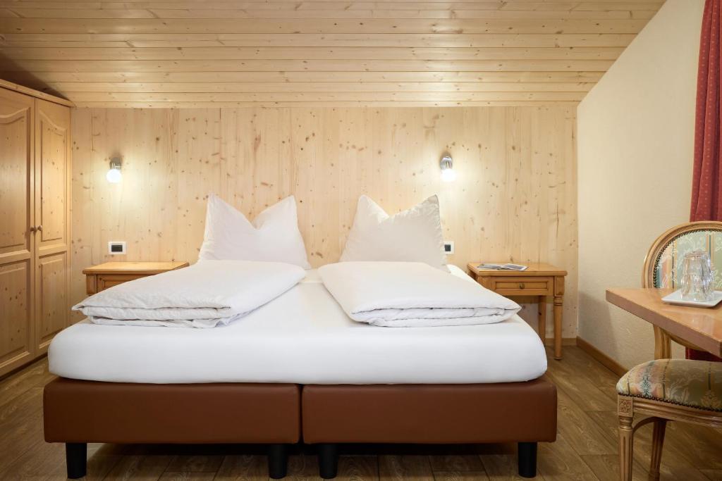 巴迪亚Hotel B&B Frohsinn的卧室配有2个白色枕头