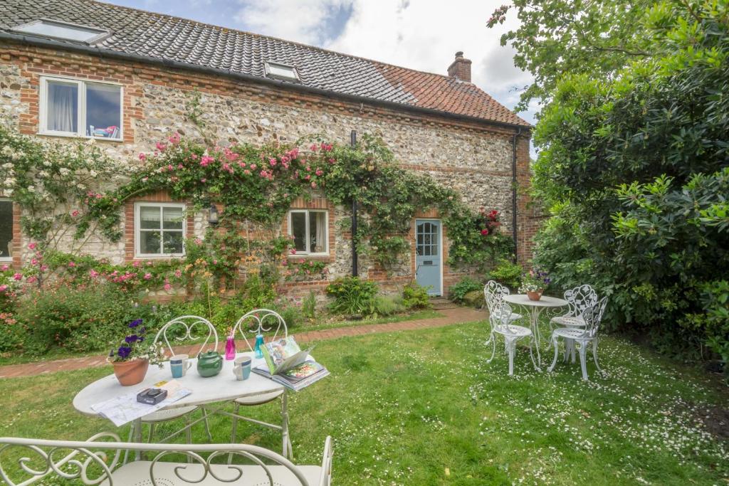 布兰克斯特Grooms Cottage B的房屋前设有带2张桌子和椅子的花园