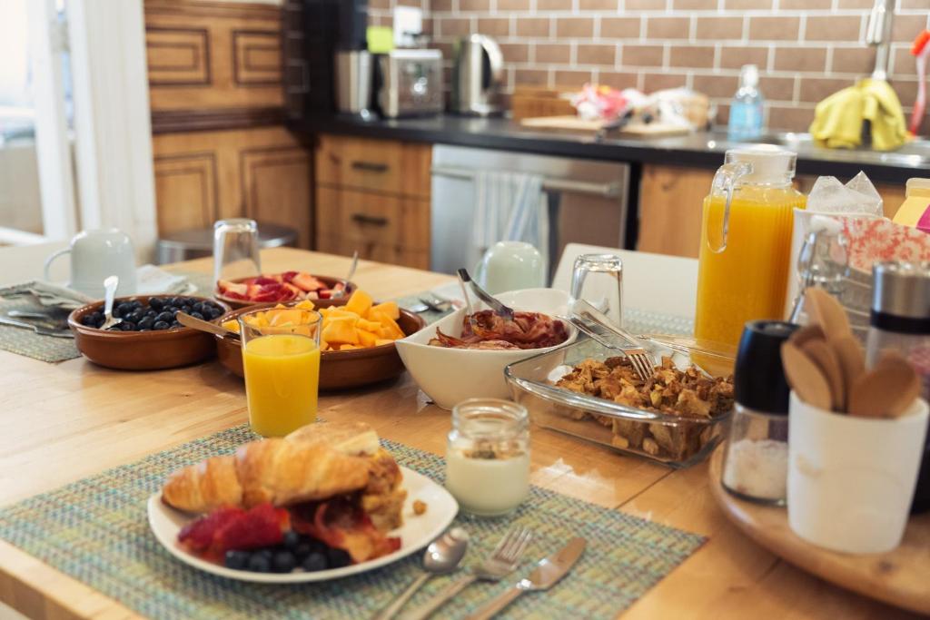 蒙特利尔Bed and Breakfast du Village BBV的餐桌上放有食物和橙汁