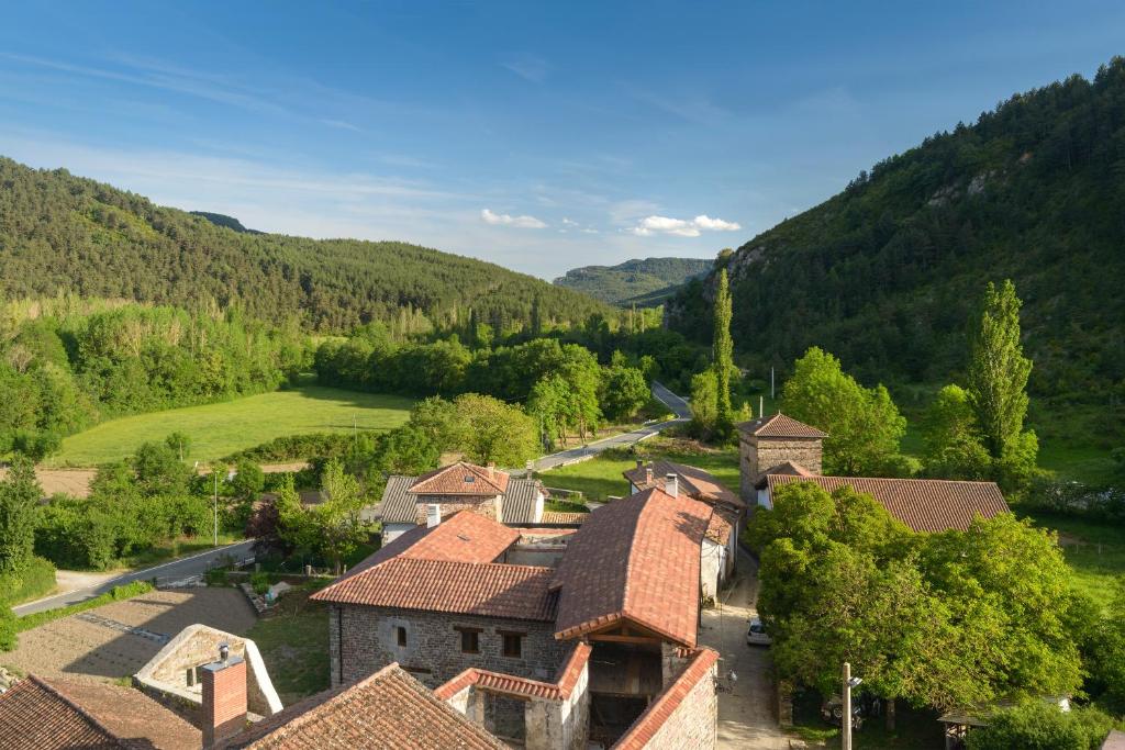 UrizHotel Rural Torre de Úriz的享有山脉村庄的空中景致