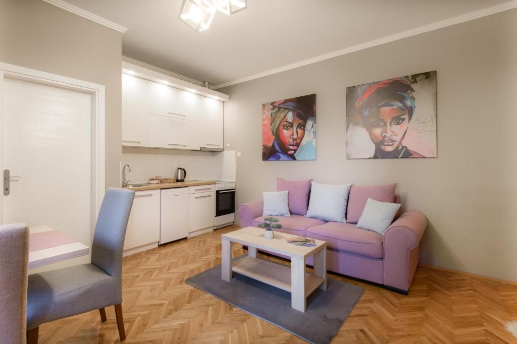 苏博蒂察DuMalux Velvet的客厅配有紫色沙发和桌子