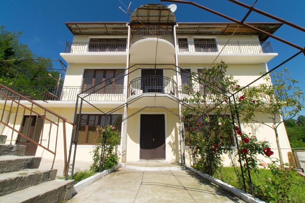茨卡尔图博Bagrat Guest House的带阳台和楼梯的白色房屋