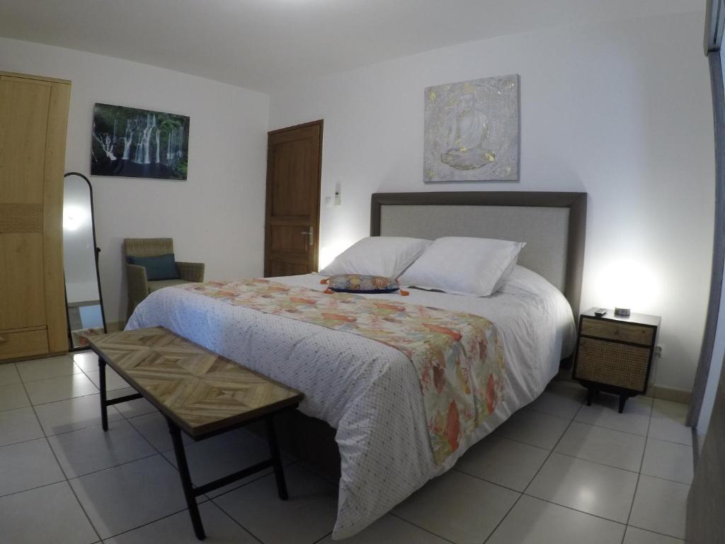 圣丹尼斯La Villa Vie d'Hôte的一间卧室配有一张大床和一张桌子