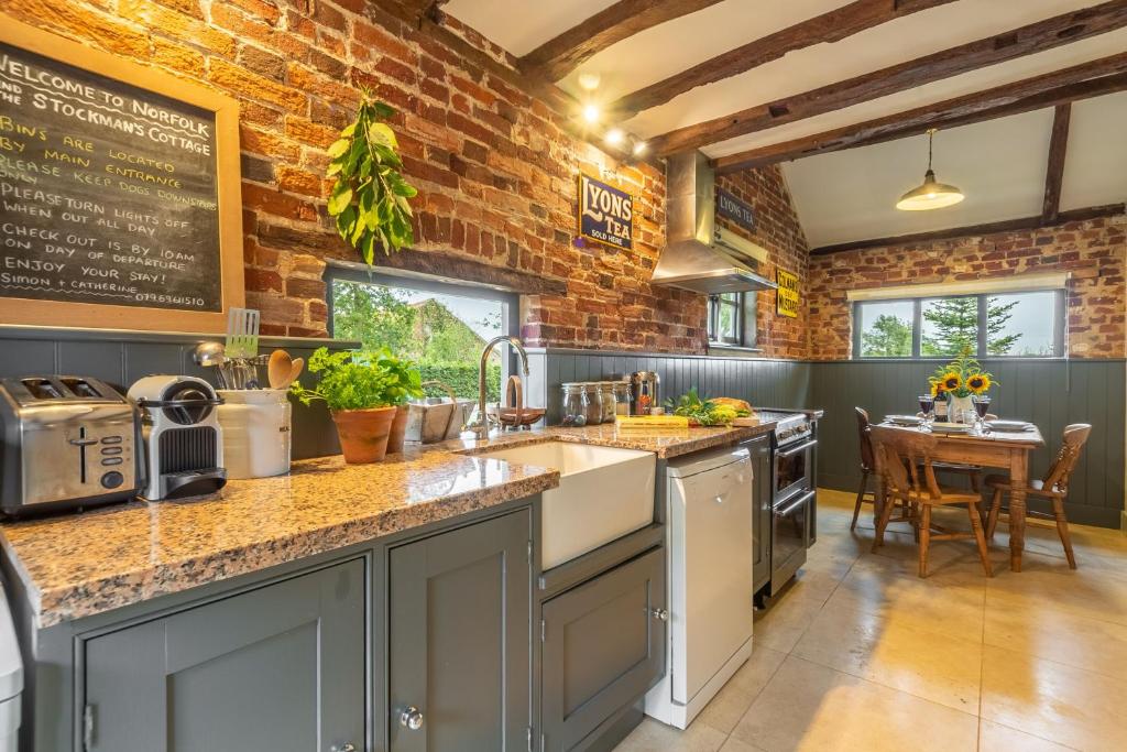 FoulshamStockmans Cottage的厨房设有砖墙和台面