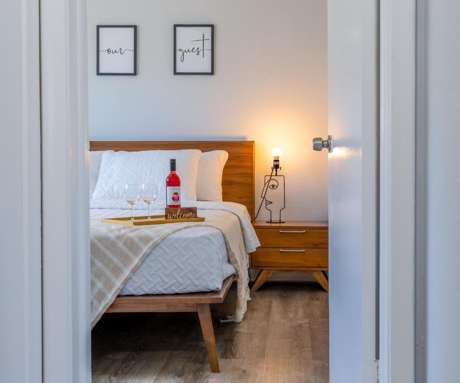 达尼亚滩AirportHouse的一间卧室配有一张带两杯葡萄酒的床