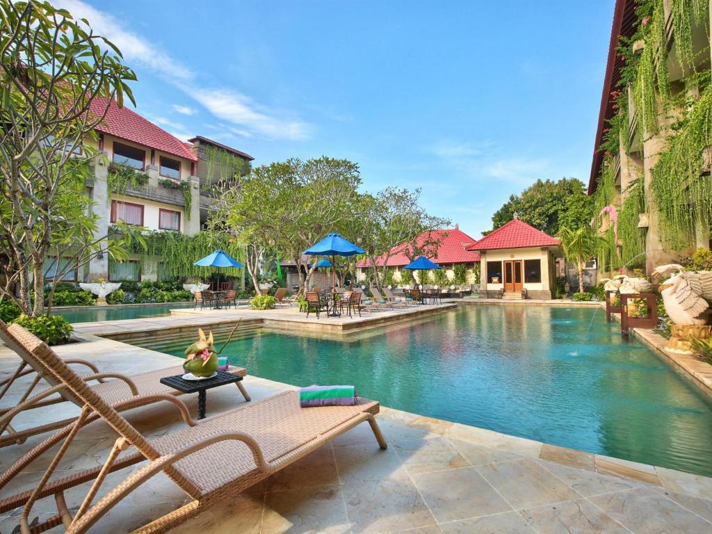 努沙杜瓦豪华巴厘岛努沙杜瓦酒店的一个带桌椅的度假村游泳池