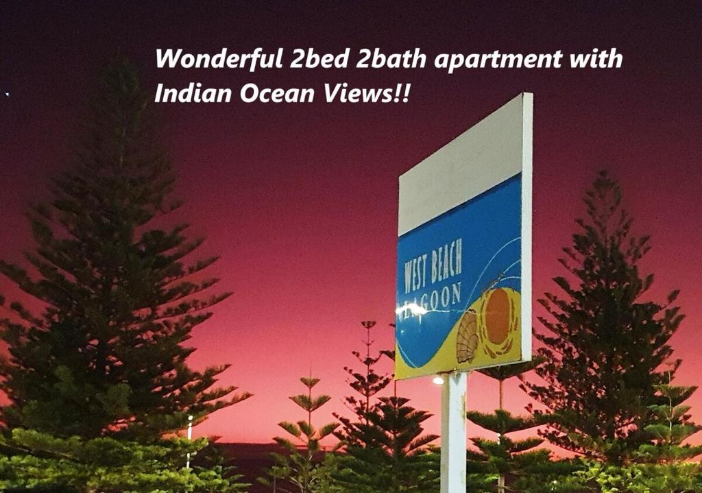 珀斯Wonderful 2bed 2bath Apartment With Ocean Views !的两棵树前的标志,日落