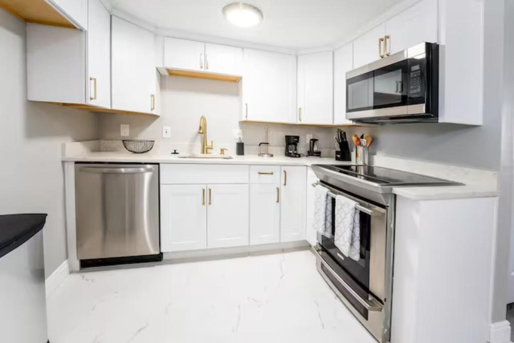 丹佛All New! Convenient Location! Sleeps 8的厨房配有白色橱柜和不锈钢用具