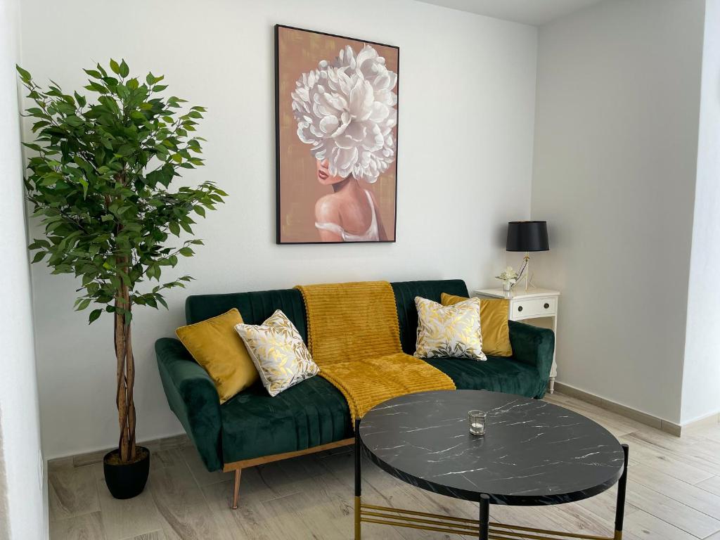波尔蒂芒Our Charming House的客厅配有绿色沙发和桌子