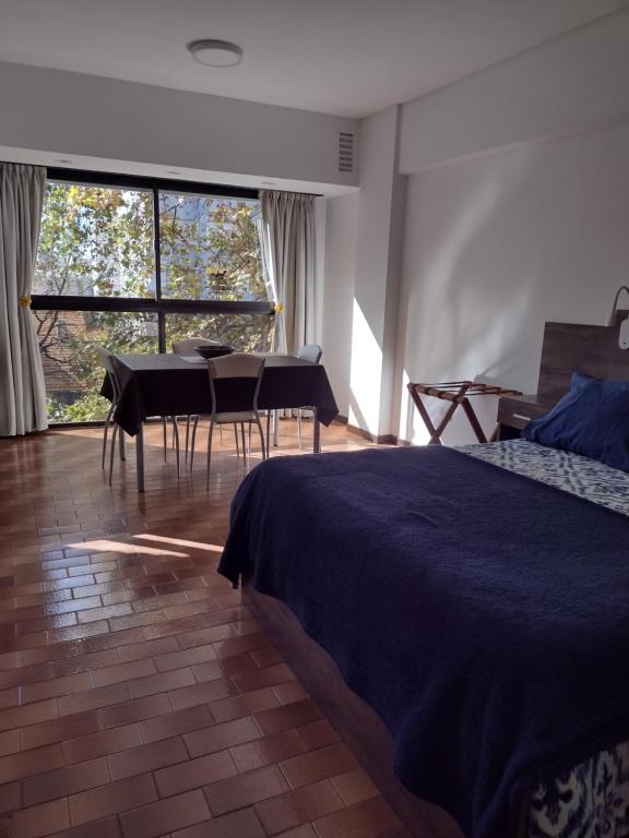 马德普拉塔Luminoso Ambiente, con cochera en lo mejor de La Perla的卧室配有一张床和一张桌子及椅子