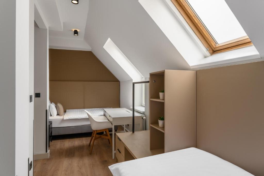 布达佩斯Florin Apart Hotel的一间卧室配有一张床、一张书桌和一个窗户。