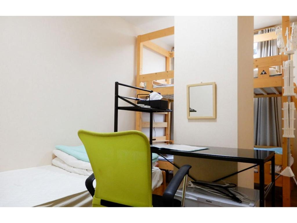 鸟取市Tottori Guest House Miraie BASE - Vacation STAY 41214v的客房配有书桌和绿椅。
