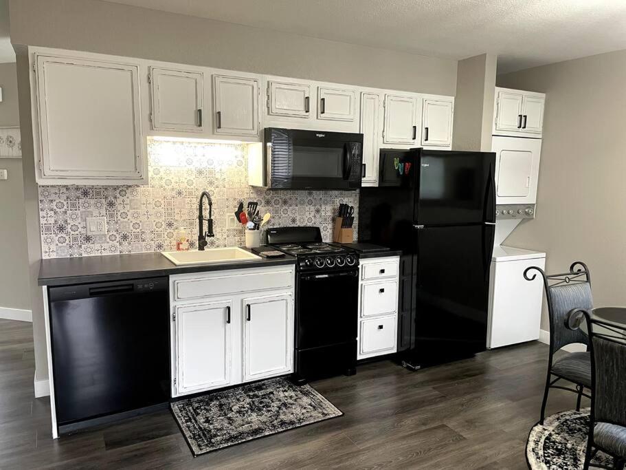 布兰森New Remodeled Luxury Condo By The Lake, No Stairs!的厨房配有黑冰箱和白色橱柜。