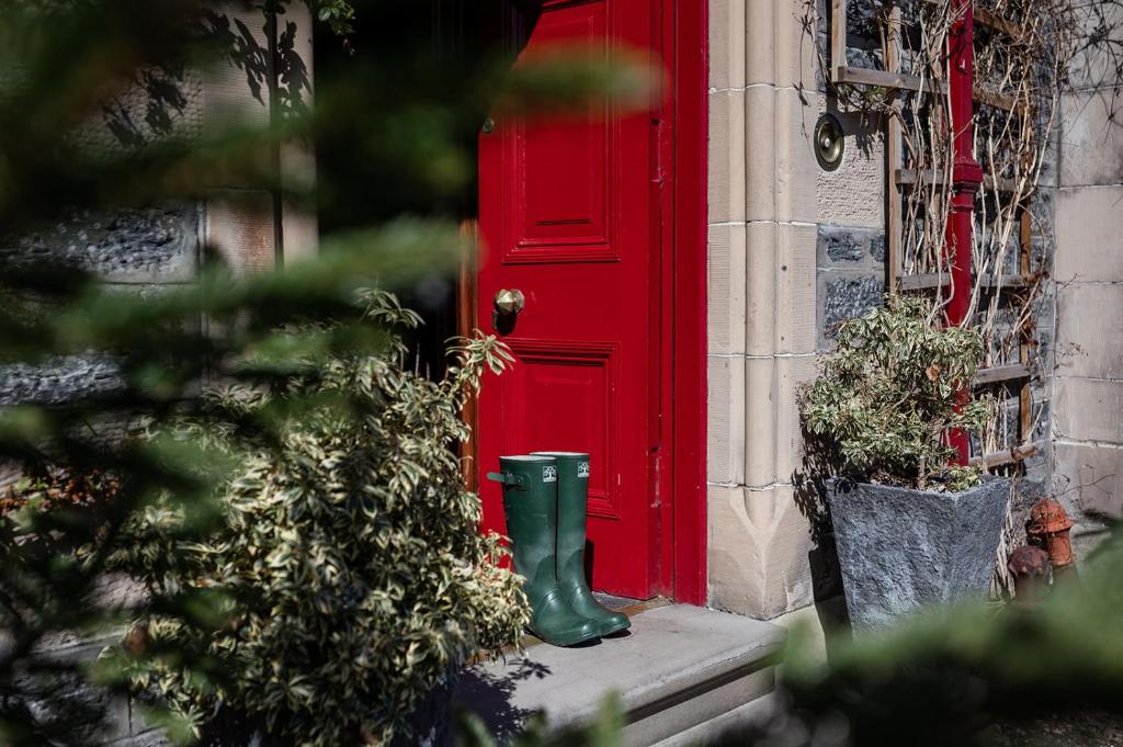 斯佩河畔格兰敦斯特拉撒伦住宿加早餐旅馆的前面有绿靴的红色门